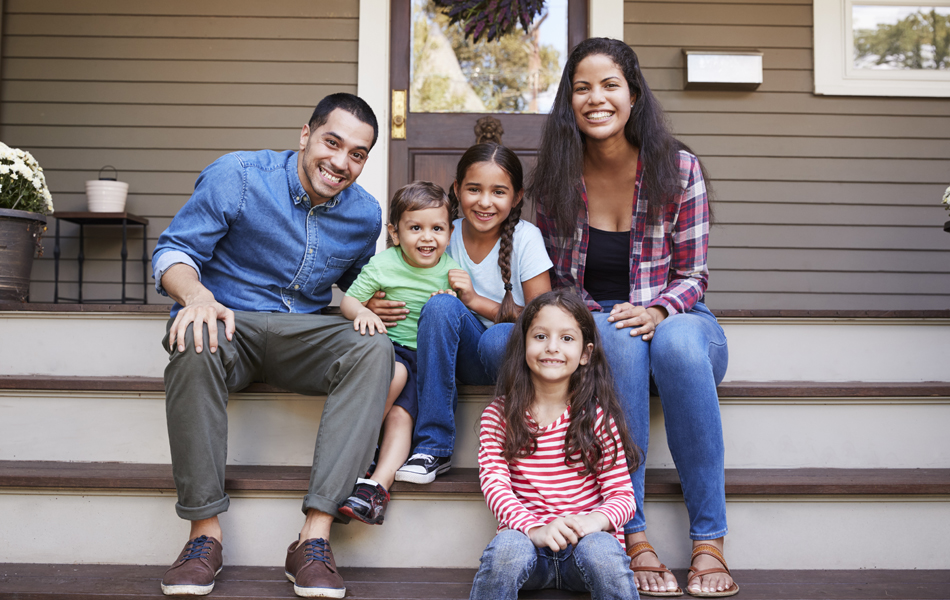 Young family of five sitting on their outdoor deck  steps where they entertain family and friends